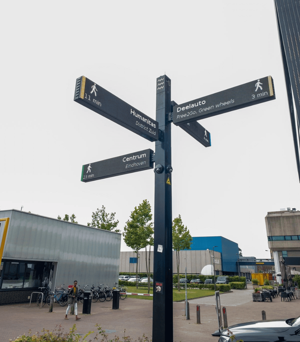 Detail van een slanke outdoor informatiemast met geïntegreerde LED schermen voor stedelijke navigatie in gemeente Eindhoven