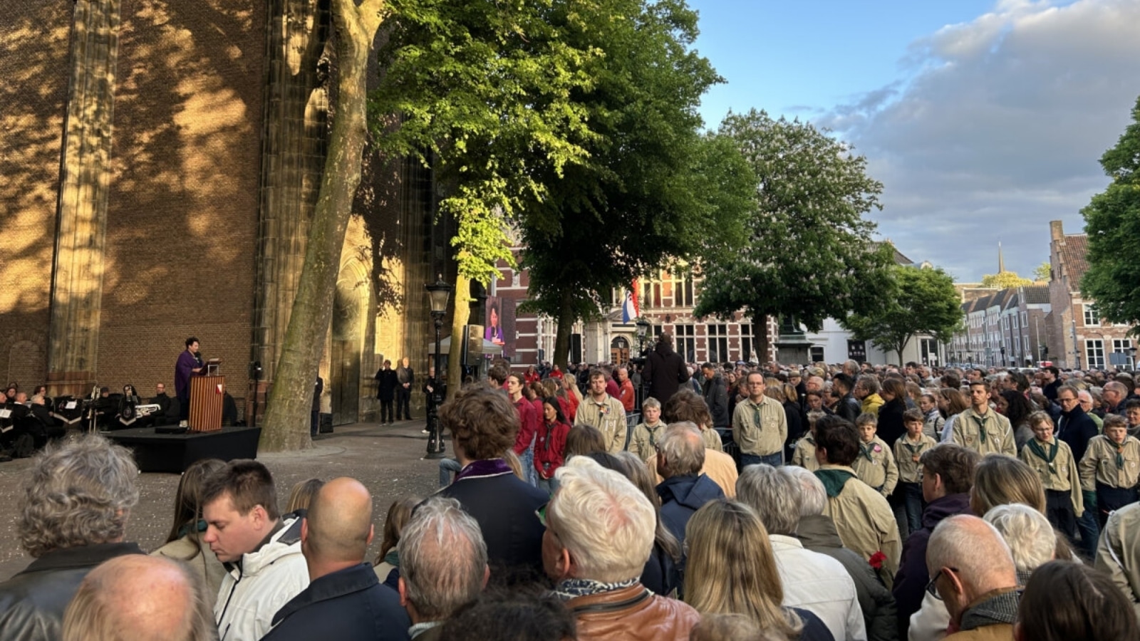 Groot publiek op het Domplein in Utrecht kijkt naar een LED-scherm tijdens de Dodenherdenking op 4 mei.