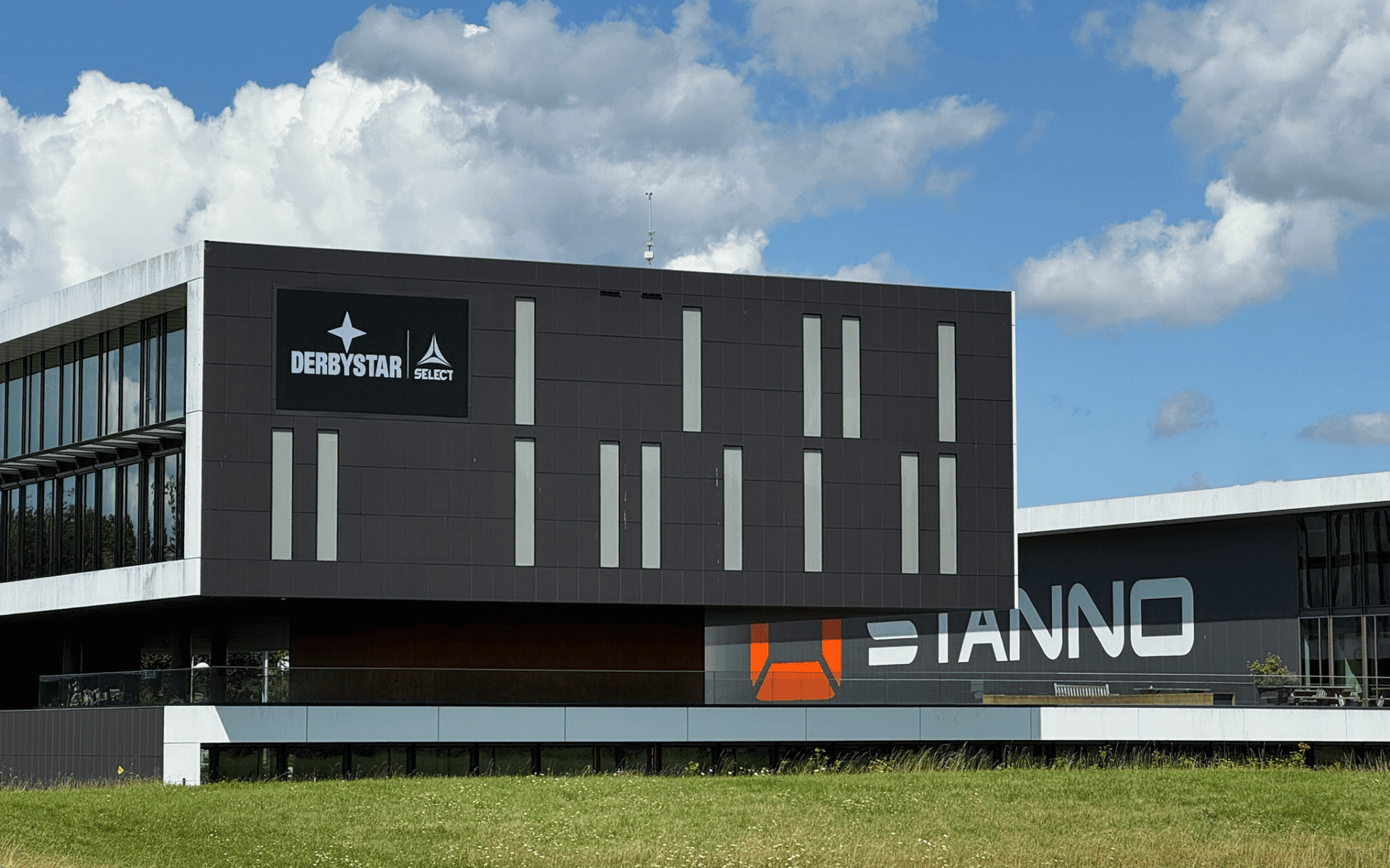 Naadloze integratie van een digitaal LED-informatiebord in de donkere gevel van een modern kantoorpand.