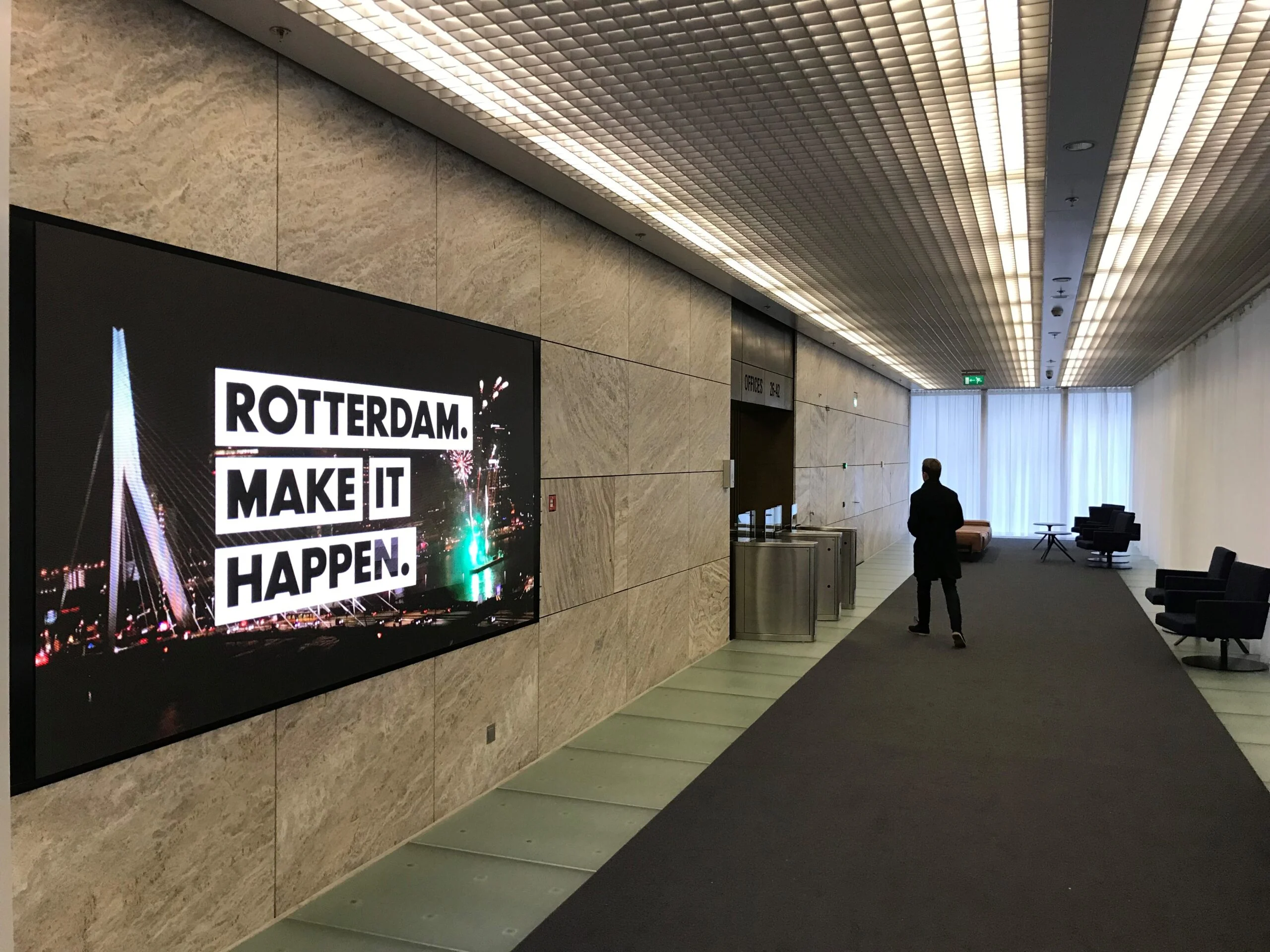 Wandvullend LED-scherm in een moderne gang vertoont dynamische branding content voor zakelijke communicatie.