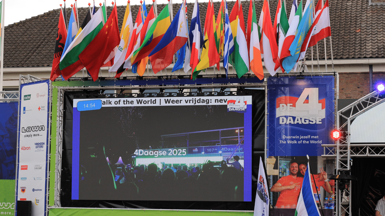 Een modulair outdoor LED-scherm uitgerust met geïntegreerde vlaggenmasten voor optimale event-branding en zichtbaarheid tijdens de Nijmeegse Vierdaagse.