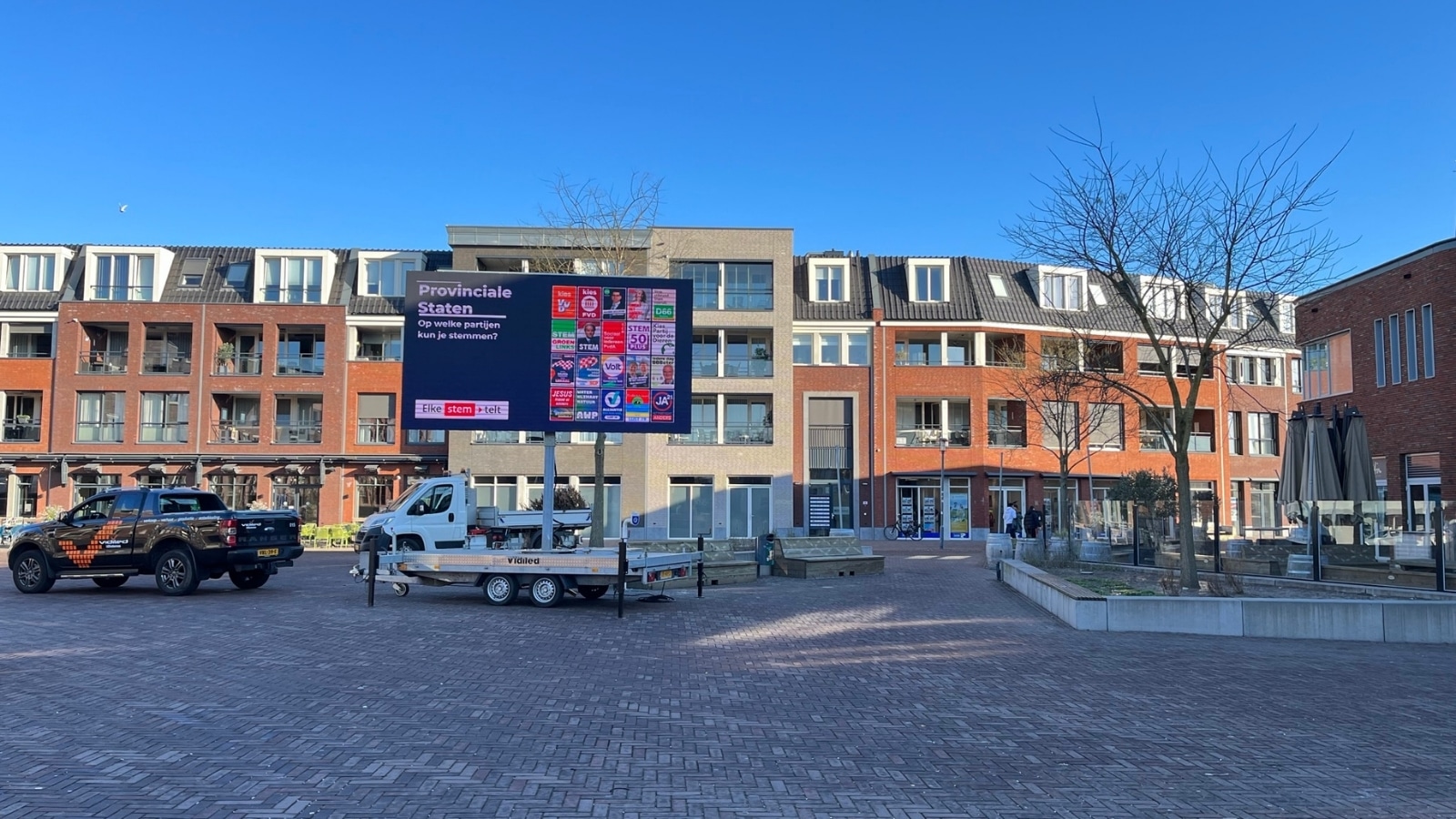 Verrijdbaar LED-display van Vidiled op een aanhanger, ingezet voor politieke campagnes en verkiezingen in een woonwijk.