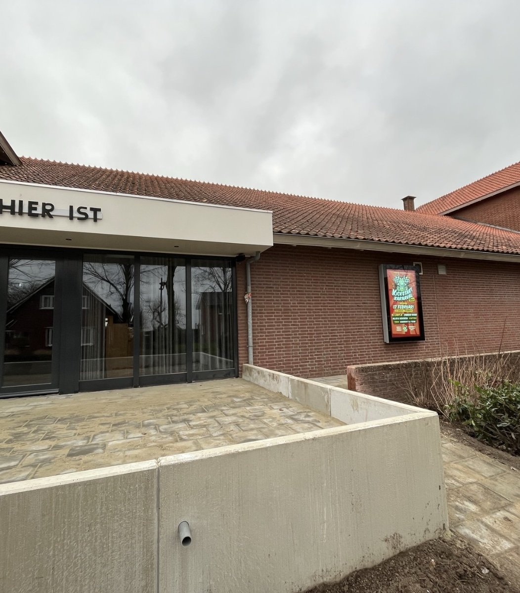 Installatie van een vandalismebestendig LCD scherm door Vidiled bij een gemeenschapsgebouw.