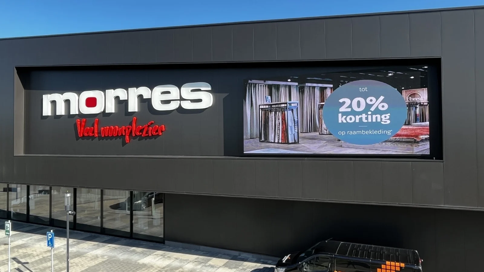 Close-up van Vidiled LED-display op de gevel van Morres Wonen Hulst met zichtbare kortingsadvertentie.