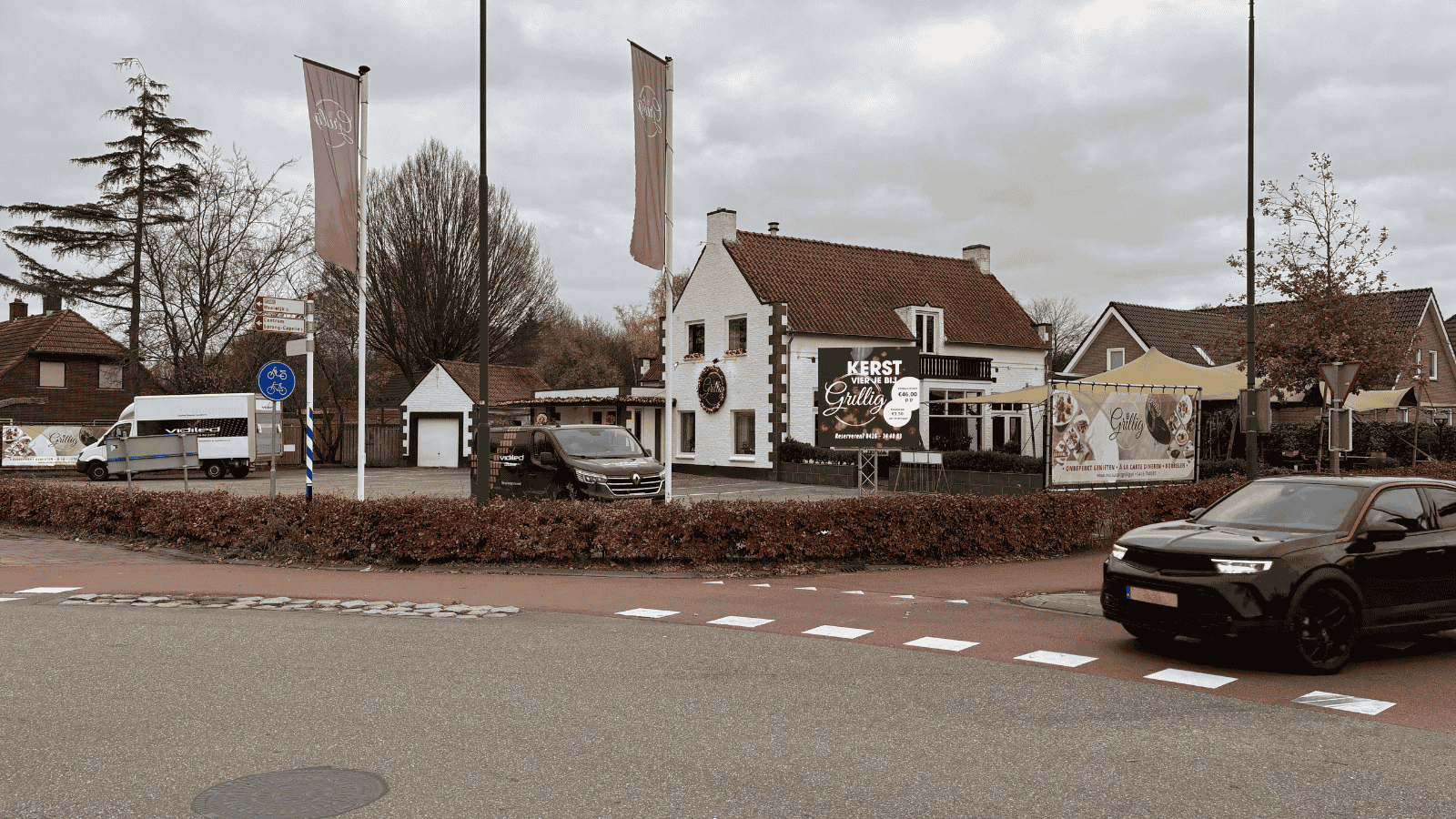 Totaaloverzicht van Restaurant Grillig in Kaatsheuvel met Vidiled LED-reclamescherm en vlaggen langs de ingang tijdens kerstperiode