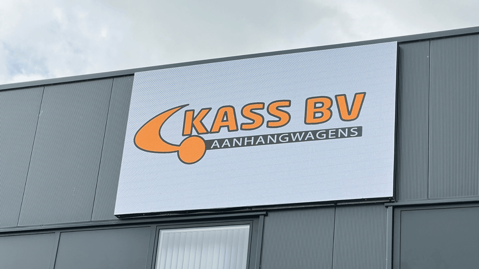 Detailopname van een hoge resolutie outdoor LED-wall van Vidiled met het bedrijfslogo van Kass BV Aanhangwagens.