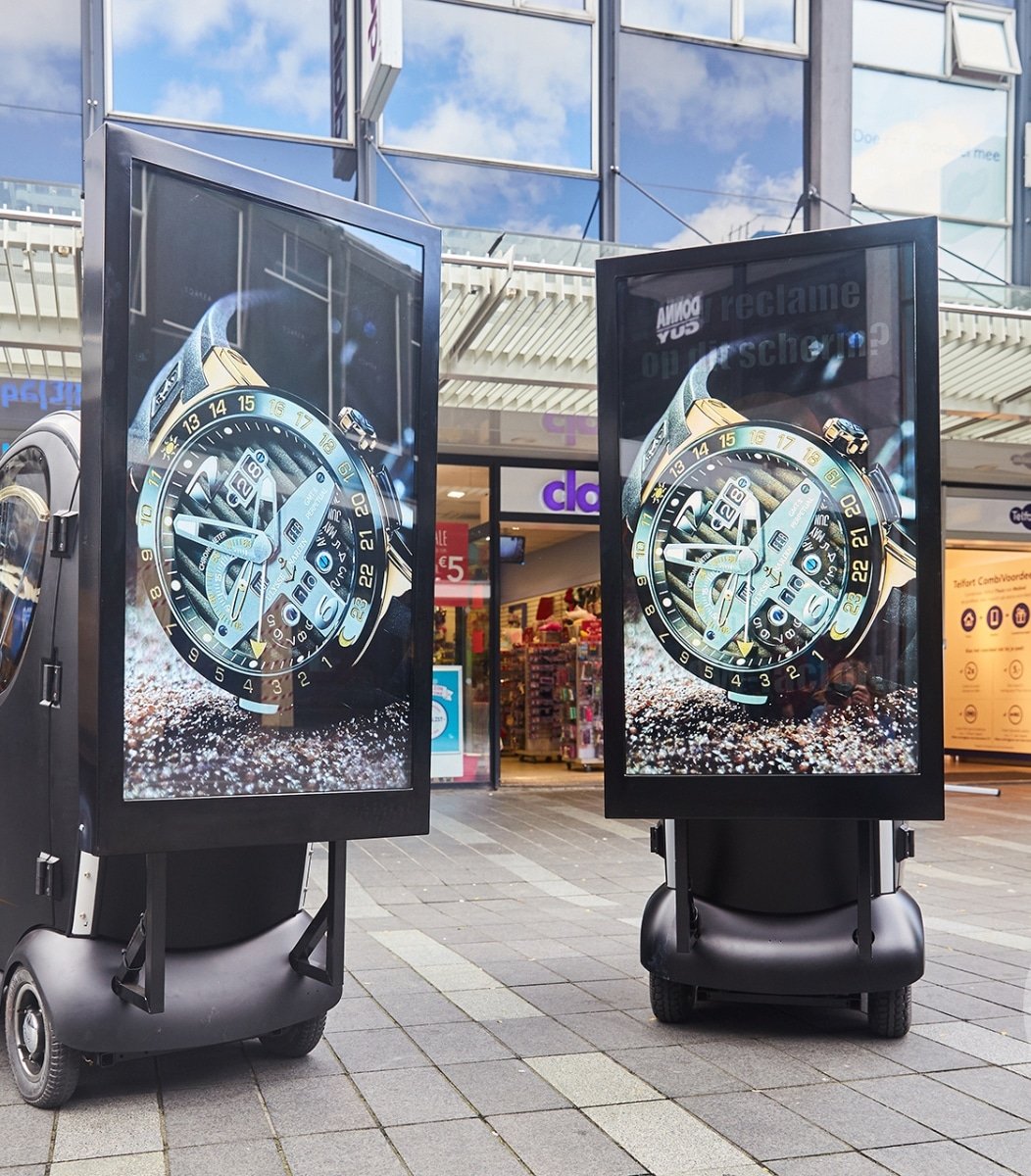 Twee Vidiled Q-karren met LED-schermen opgesteld op een druk plein voor straatgerichte reclamecampagne